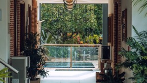 Een modern interieur met een betegelde vloer, een hanglamp en potplanten.