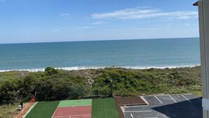 En tennisbane med udsigt til havet og stranden.