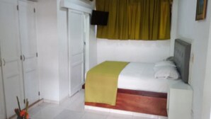 Un dormitorio con cama, armario, aire acondicionado y televisor.