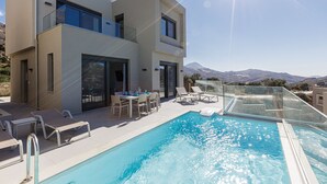 A modern two-story house with a swimming pool, outdoor seating, and a mountain view. - Porti Iraklis 4 - A Stylish Eco Villa near beaches (Rethymno)