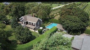 Enjoy a serene retreat in this two-story house surrounded by lush greenery and a swimming pool.