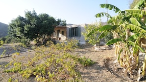 A rustic house with a stone facade, a wooden door, and a small porch. - Dolly's Dream House (Patmos)