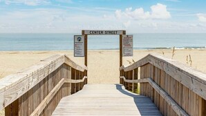 Un muelle de madera que conduce a una playa, con un cartel que dice "CENTER STREET".
