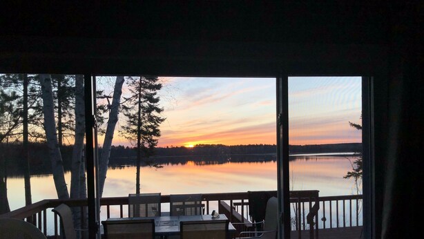 A view from a room with a large window overlooking a calm lake at sunset. - Little Bass Cabin - Kayaks & Clear Water Swimming (Grand Rapids)