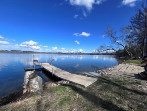 A calm lake with a dock, grassy area, and trees. - Little Bass Cabin - Kayaks & Clear Water Swimming (Grand Rapids)