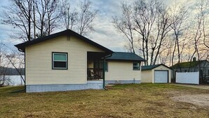 A single-story house with a front porch and a garage. - Little Bass Cabin - Kayaks & Clear Water Swimming (Grand Rapids)