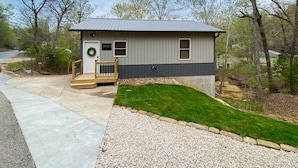 A small, single-story cabin with a metal roof, a front porch, and a mailbox. - Beach Access to Ozark, Visit the Cottage on Valley Road! (Osage Beach)