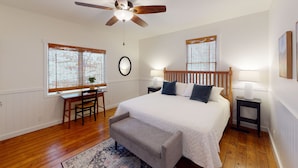 A bedroom with a bed, a desk, and a chair. There is a ceiling fan, two windows with blinds, and a rug on the floor. - Beach Access to Ozark, Visit the Cottage on Valley Road! (Osage Beach)