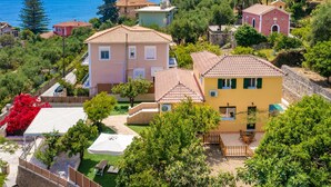 A residential area with houses, a beach, and a mountain in the background. - Avrochares Villa (Ζάκυνθος)