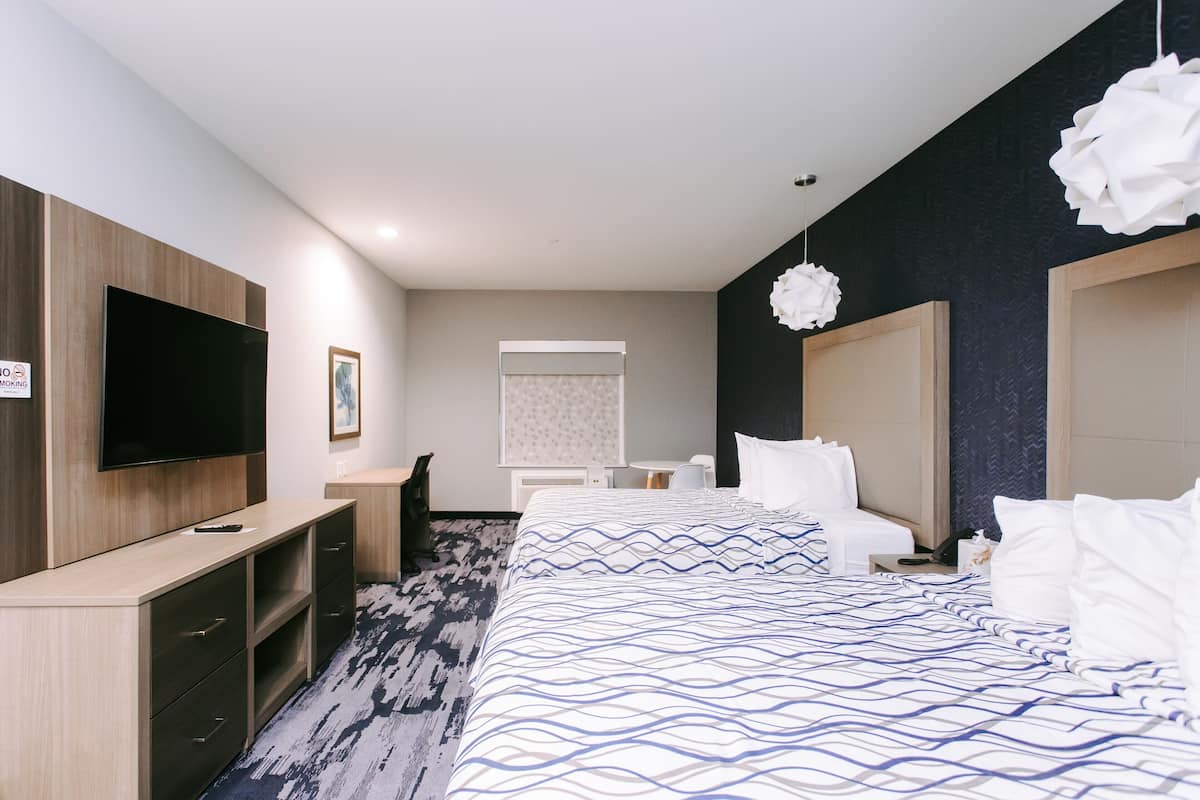 A hotel room with a large bed, a flat-screen TV, a desk, and a chair.
