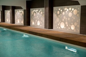 Una piscina techada, sillones reclinables de piscina