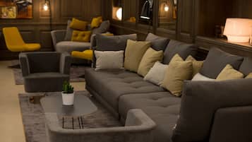 A modern living room with a grey sectional sofa, a small round table, and a yellow armchair.