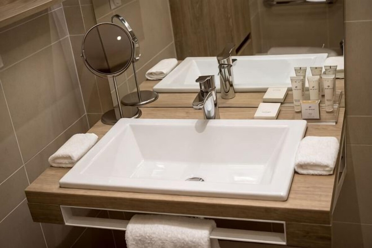 Een badkamer met twee wastafels, een spiegel en toiletartikelen.