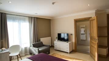 Une chambre d’hôtel comprenant un lit, un bureau, une chaise, un téléviseur et une armoire.