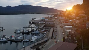 A coastal town with a marina, docked boats, and a road leading to the town center. - Downtown Ketchikan /million Dollar View (Ketchikan)