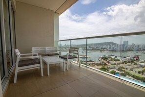 A balcony with white furniture, a view of a cityscape, and a body of water. - Spectacular apartment in H2, 20th floor! (Cartagena)