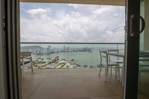 A balcony with a view of a cityscape, including a body of water and buildings. - Spectacular apartment in H2, 20th floor! (Cartagena)