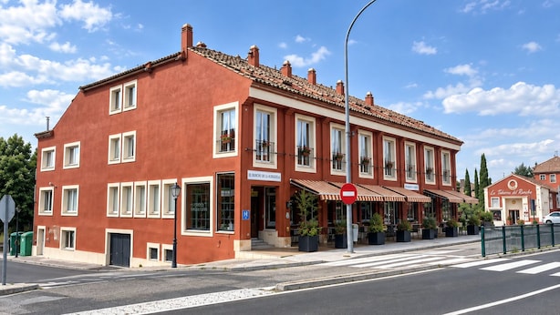 Un edificio rojo con varias ventanas y un cartel que indica un banco y un restaurante.