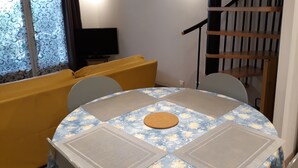 A dining area with a round table, chairs, and a sofa. - Nice Appart T3 duplex 4pers-Clim- 5mn from the Port Ostréicole de la Teste de Buch (La Teste-de-Buch)