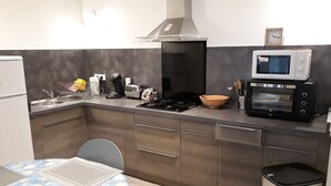 A modern kitchen with a gas stove, microwave, toaster, and sink. - Nice Appart T3 duplex 4pers-Clim- 5mn from the Port Ostréicole de la Teste de Buch (La Teste-de-Buch)