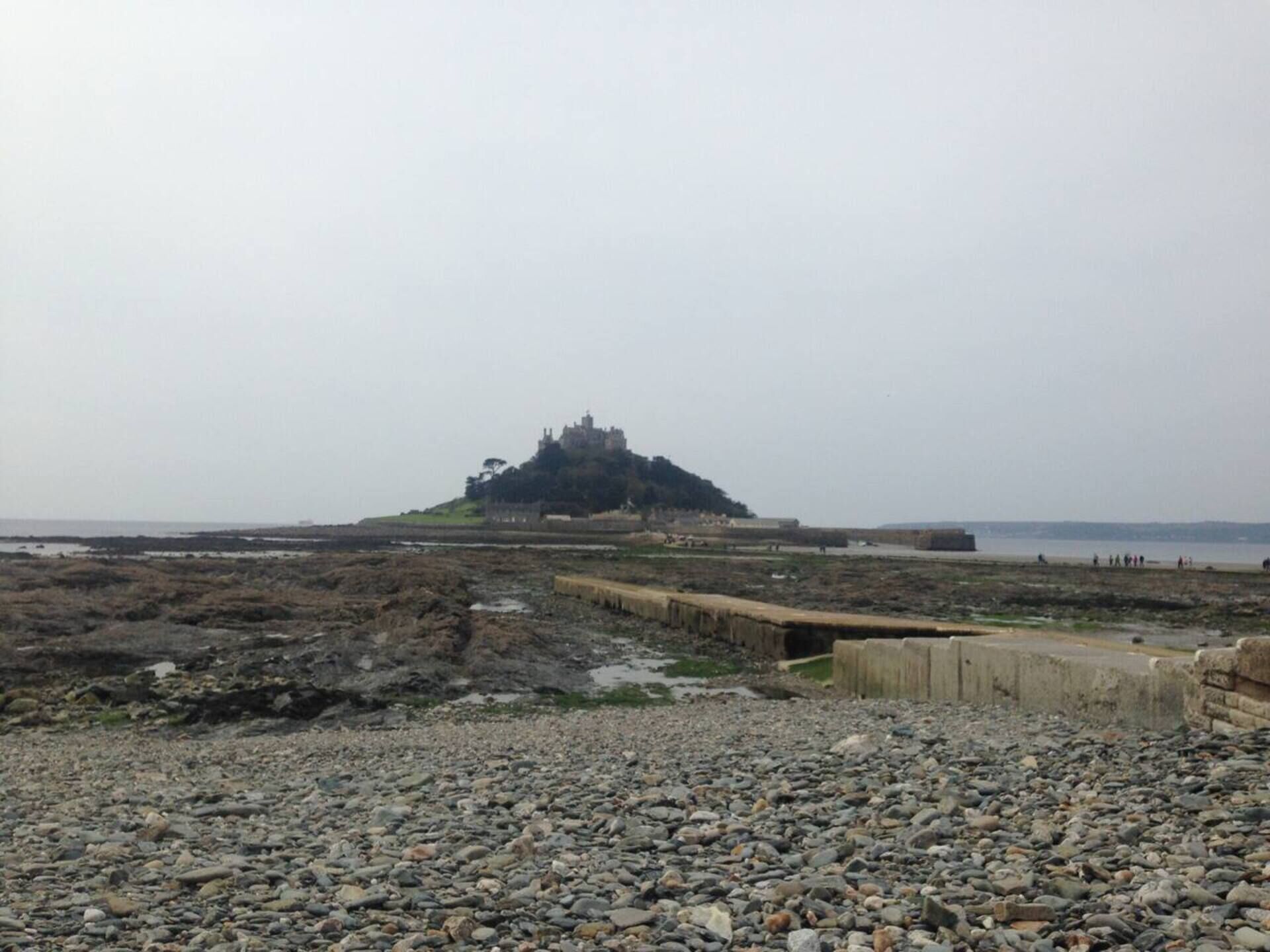 Un castillo sobre una colina rocosa con vista al mar.