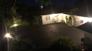 A small, white building with a single entrance and a lit exterior.