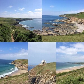 A coastal landscape with rocky cliffs, a beach, and a lighthouse.