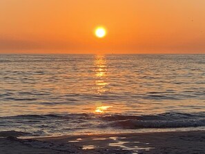 Ein Sonnenuntergang über ruhigem Meer mit klarem Horizont.