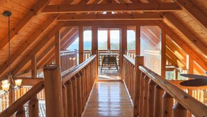 A wooden interior with a central wooden walkway leading to an outdoor deck. - Secluded Cabin w/Mtn. Views, 3 Decks & Theater (Sevierville)