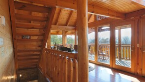 A wooden interior with a staircase leading to a balcony. - Secluded Cabin w/Mtn. Views, 3 Decks & Theater (Sevierville)