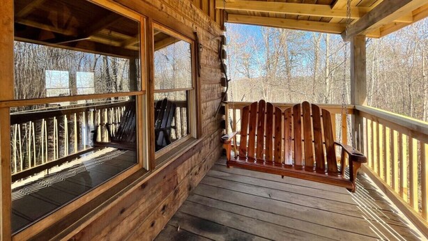 A wooden cabin with a porch, large windows, and a wooden chair. - Rustic Retreat 2 BD/1 BA cabin near Pigeon Forge (Sevierville)