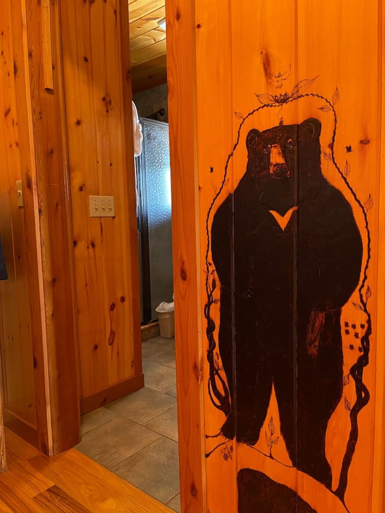 A wooden interior with a large bear mural on a door.