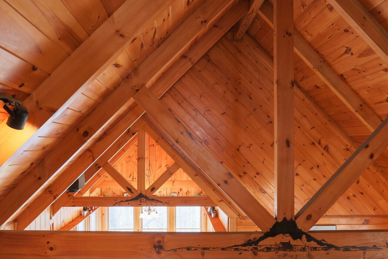 A wooden attic with exposed beams and a sloped ceiling.