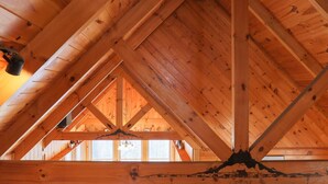 A wooden attic with exposed beams and a sloped ceiling. - Rustic Retreat 2 BD/1 BA cabin near Pigeon Forge (Sevierville)