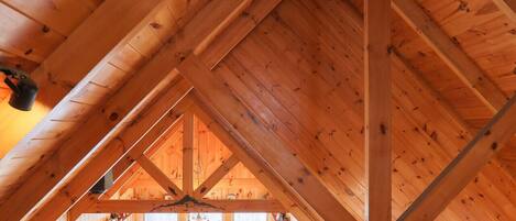A wooden attic with exposed beams and a sloped ceiling.
