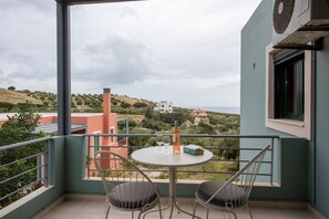 Enjoy a serene view of the surrounding hills from this balcony, complete with a table for two.
