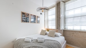 A bedroom with a bed, a window, and three framed pictures on the wall. - GuestReady - Oporto Temptation Apartment (Porto)