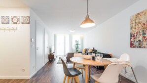 Un espace repas moderne avec une table ronde, des chaises et un luminaire suspendu.