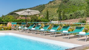 A poolside area with lounge chairs and a large umbrella. - PRIVATE POOL - AGRITURISMO FATTORIA LA PIEVE - VILLA NERINO 8 km from Pisa  (Calci)
