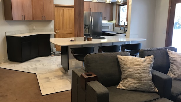 Een moderne keuken met houten kastjes, een centraal eiland en hanglampen.