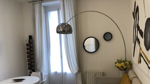 A modern, well-lit room with a dining area, a sofa, and a radiator. - House Giussano, elegant two-room apartment in the center (Milano)