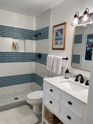A bathroom with a white sink, black faucet, and a framed picture above the mirror. - Kona Keauhou Newly Remodeled Home, Quiet private home on Golf course with
Pool. (Kailua-Kona)