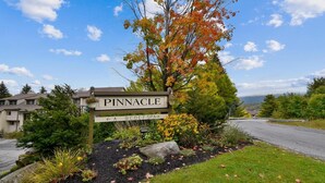 Un panneau indiquant la direction de Pinnacle, avec des indications pour accéder aux différents services, tels que A, B, C, D, E, F et le centre de bien-être.