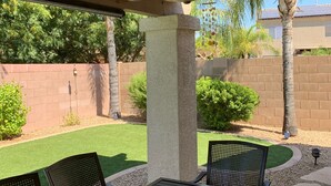 Une terrasse extérieure dotée d’un ventilateur de plafond, d’une table et de chaises.