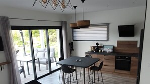 Een moderne keuken met een eetgedeelte, met een grote tafel, stoelen en een kleine ronde tafel.