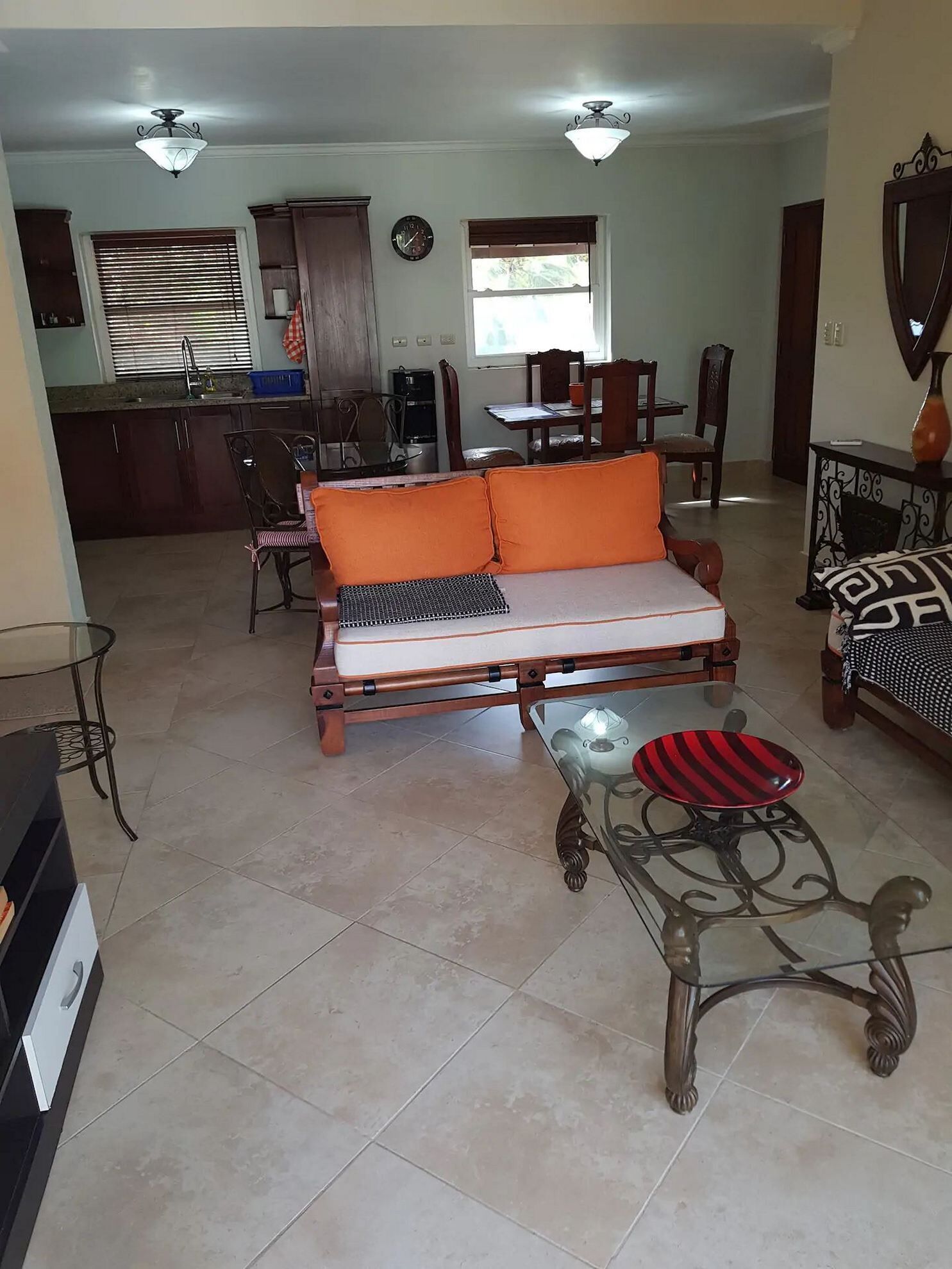 A living room with a sofa, a coffee table, and a dining area with chairs and a table.