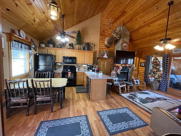 Eine gemütliche Kücheneinrichtung im Chalet-Stil mit Holzschränken, einer zentralen Kochinsel und einem aufgehängten Hirschgeweih.