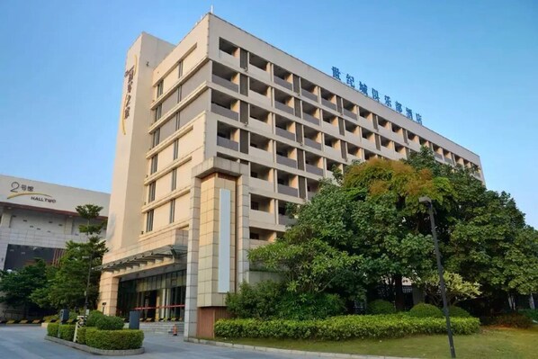 A multi-story hotel with a modern architectural design, featuring a prominent entrance and a well-maintained garden area.