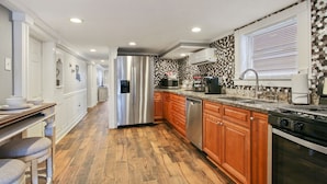 Una cucina moderna con mobili in legno, elettrodomestici in acciaio inossidabile e piastrelle decorative.