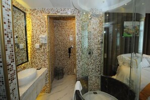 Un baño moderno con un lavabo grande, una cabina de ducha con mampara de vidrio y un espejo.
